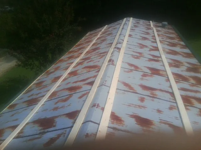 Rusted metal roof panels with new wood purlins before replacement — Storm Damage Roof Repair in Century by Roofing Brothers